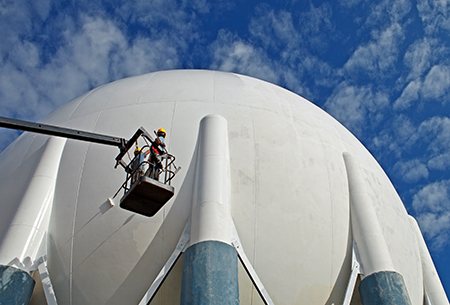 Worker-elevated-on-a-cherry-picker-in-front-of-large-sphere